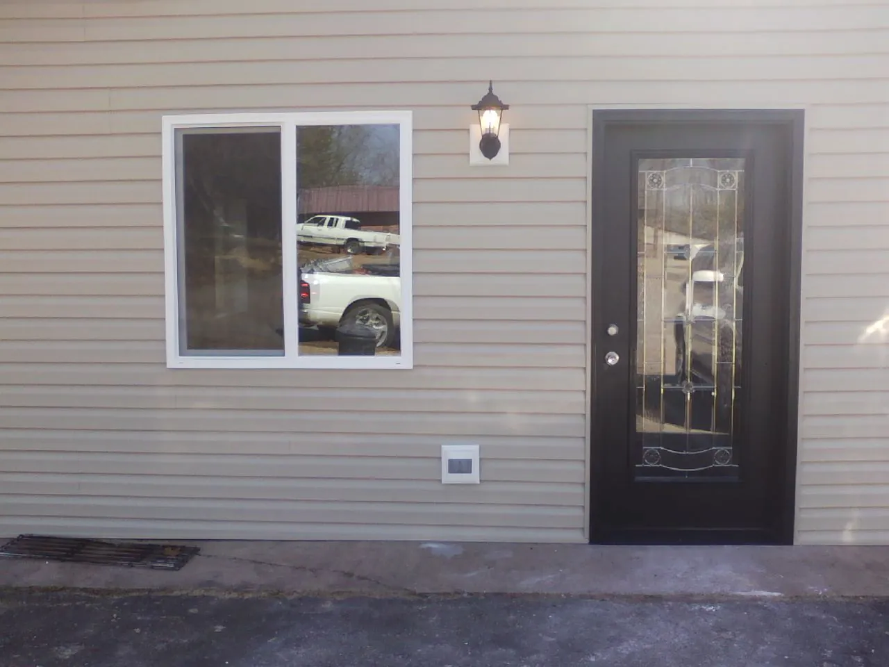 New siding, window and entry door on the side of an addition in Iona